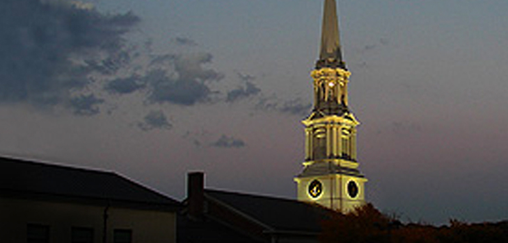 The lit steeple in the early evening